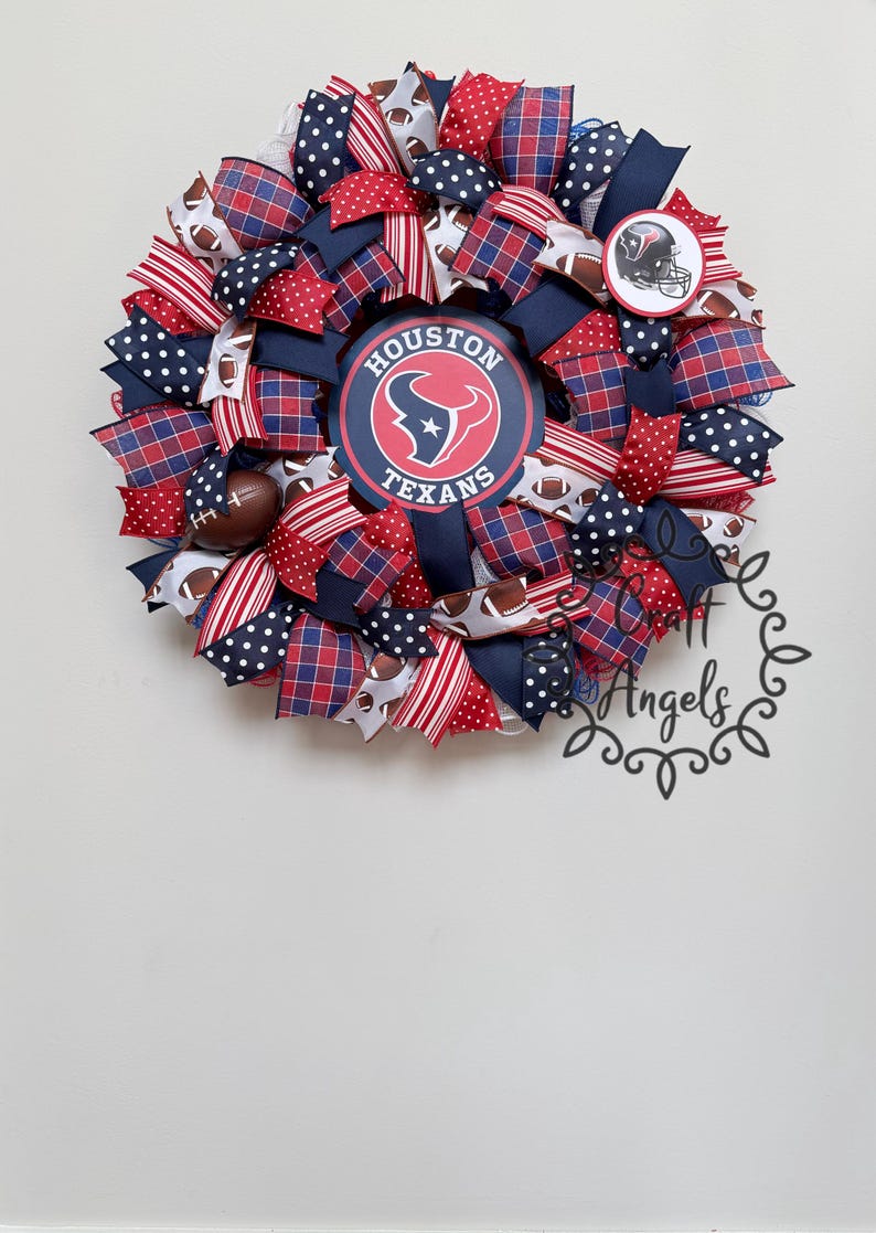 May include: A decorative wreath featuring the Houston Texans logo in the centre, surrounded by red, white, and navy blue mesh ribbons. The design includes patterns of polka dots, plaid, and footballs, with a small Texans helmet emblem.