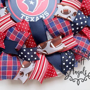 May include: A decorative wreath featuring a central Houston Texans logo sign surrounded by ribbons in red, white, and navy blue. The ribbons display patterns including red and blue plaid, white polka dots on navy, red stripes, and football graphics.