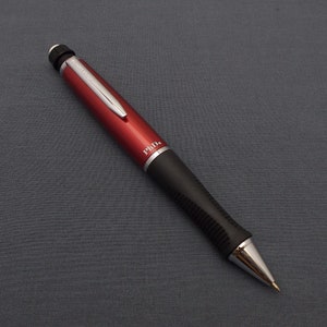 Könnte beinhalten: Ein rot-schwarzer mechanischer Bleistift mit silberner Klammer und silberner Spitze. Der Bleistift trägt die Aufschrift "PhD." auf der Seite.
