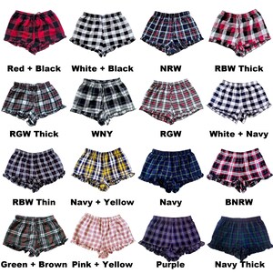 Puede incluir: Una colecci&oacute;n de 16 pares de pantalones cortos de pijama a cuadros con dobladillos con volantes. Los pantalones cortos est&aacute;n en varias combinaciones de colores, incluyendo rojo y negro, blanco y negro, azul marino y amarillo, y verde y marr&oacute;n.