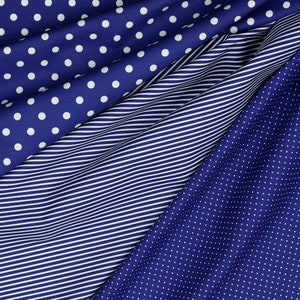 May include: Three different blue fabrics with white patterns. The top fabric has large white polka dots, the middle fabric has thin white stripes, and the bottom fabric has small white polka dots.