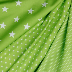 May include: Green fabric with a white star pattern. The fabric has two different patterns, one with larger stars and one with smaller stars.