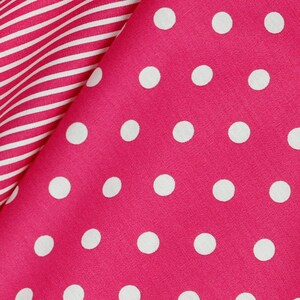 May include: Pink fabric with a white polka dot pattern. The fabric is folded over a white and pink striped fabric.