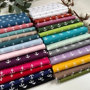 May include: A stack of 20 fabric squares with a white anchor pattern on different coloured backgrounds. The colours include white, red, pink, teal, green, brown, grey, purple, yellow, and navy blue.