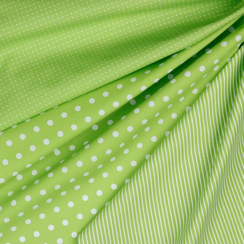 May include: Three pieces of green fabric with different patterns. The top piece has small white dots, the middle piece has larger white dots, and the bottom piece has white stripes.
