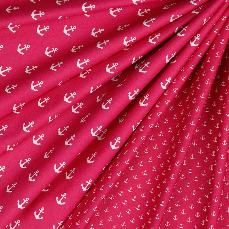 May include: Red fabric with a white anchor pattern. The fabric is folded in half, showing the pattern on both sides.