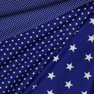May include: Two pieces of blue fabric with white stars printed on them. One fabric has small stars and the other has larger stars.
