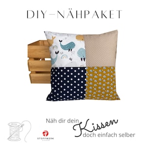 May include: DIY sewing kit for a pillow with a whale, rainbow, and polka dot pattern. The kit includes fabric, instructions, and a needle and thread. The pillow is shown in a wooden crate. The text on the image reads "DIY - NÄHPACKET" and "Näh dir dein Kissen doch einfach selber".