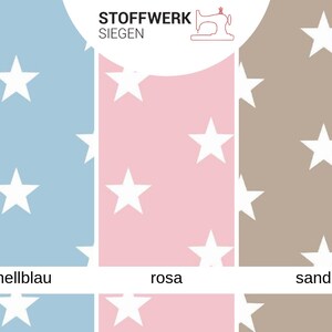 May include: A fabric swatch sampler with three different colors: light blue, pink, and brown. Each color has a white star pattern. The text "Stoffwerk Siegen" is at the top of the image.