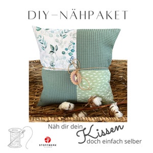 Könnte beinhalten: DIY Nähpaket für ein Kissen mit grünem und weißem Blumenmuster und grünem Waffelstoff. Das Paket beinhaltet Stoff, Garn und Anleitung. Der Text auf dem Bild lautet "DIY - NÄHPAKET Näh dir dein Kissen doch einfach selber".