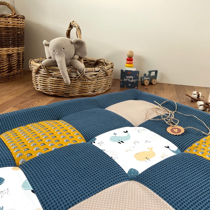 A cozy and colorful baby's room with a quilted bedspread, a wicker basket, and various toys and decorations.