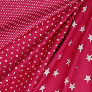 May include: Two red fabric swatches with white stars. One swatch has small white stars on a red background, and the other has larger white stars on a red background.