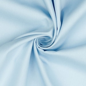 May include: A close-up of a light blue fabric with a smooth texture. The fabric is folded and twisted, creating a swirling pattern.