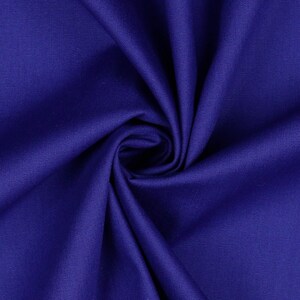 May include: Close-up of a deep blue fabric with a smooth, textured surface. The fabric is folded and draped, creating a soft, flowing look.