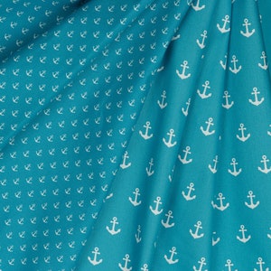 May include: A turquoise fabric with a white anchor pattern. The fabric is folded in half, showing the pattern on both sides.