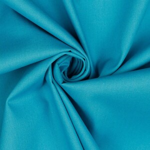 May include: A close-up of a bright turquoise fabric, folded and twisted into a spiral shape. The fabric has a smooth, slightly textured surface.