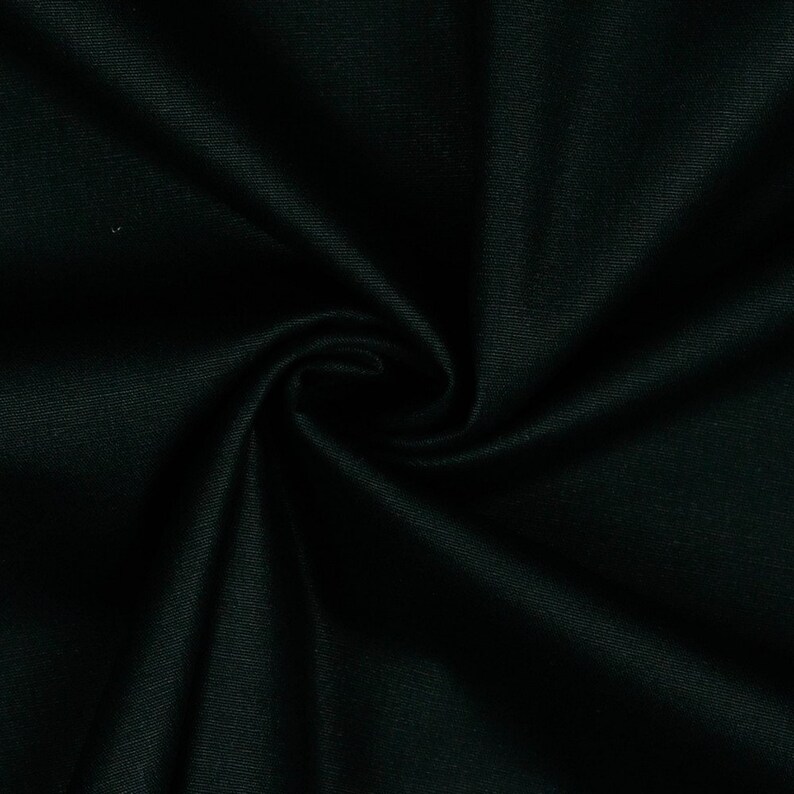 May include: Close-up of a dark green fabric with a smooth, silky texture. The fabric is folded and draped, creating soft folds and curves.