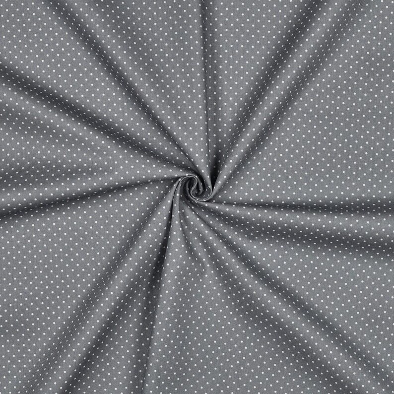 Pu&ograve; includere: Tessuto grigio con motivo a pois bianchi. Il tessuto &egrave; piegato e ha una texture.