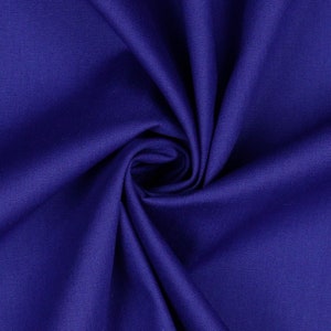 May include: Close-up of a deep blue fabric with a smooth, textured surface. The fabric is folded and draped, creating a soft, flowing look.