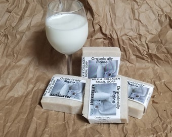 May include: Four bars of handmade soap with the label "Organically Maine" and the text "Milk & Collagen Facial Soap" and "Katahdin Cut 4 oz". The soap is on a brown paper background with a glass of milk.
