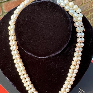 Lustrous cultured pearl necklace with 18 carat white gold and emerald clasp