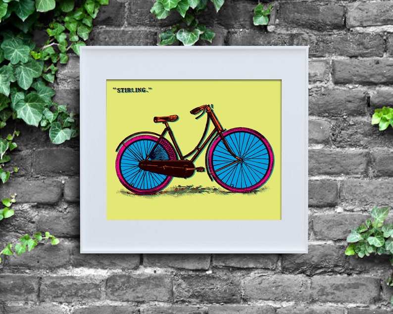 May include: A framed print of a bicycle illustration. The bicycle has blue wheels with pink rims, a brown seat, and a brown and pink frame. The background is yellow, and the text "STIRLING." is at the top.