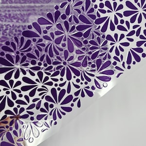 May include: A sheet of clear plastic with a repeating pattern of purple floral designs. The floral pattern is embossed, creating a raised texture. The design is a mix of stylized flowers and teardrop shapes.