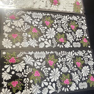 May include: Three sheets of white floral stickers with pink flowers and green leaves. The stickers are on a clear plastic background.