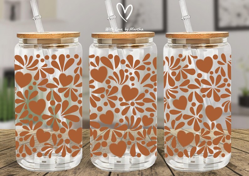 May include: Clear glass drinking jars with brown heart and floral patterns, bamboo lids, and clear straws. The jars are displayed on a wooden surface. The text "With Love, by Martha" is visible on the top.