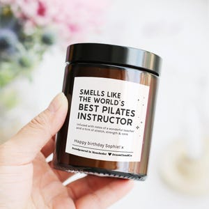Candle that reads 'smells like the world's best pilates instructor' with customisable message on label. Birthday gift for pilates instructor.