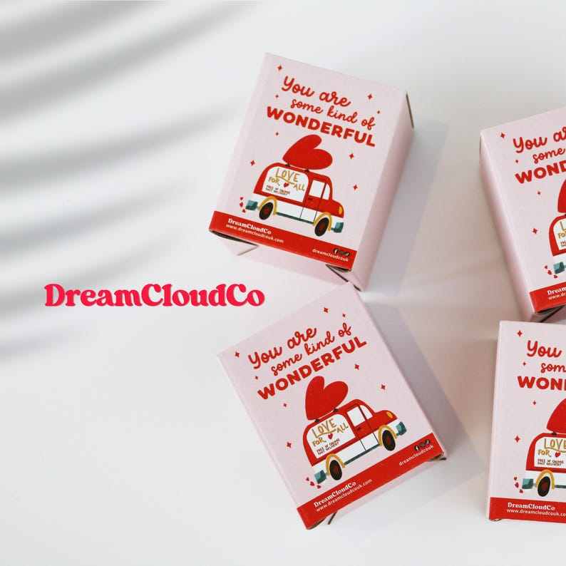 May include: Light pink rectangular boxes featuring the red text You are some kind of WONDERFUL and a graphic of a red van carrying a large red heart with the text LOVE FOR ALL. The brand name DreamCloudCo is printed in red.