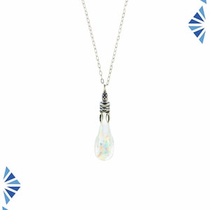May include: A silver chain necklace with a teardrop-shaped pendant. The pendant is made of clear glass with iridescent glitter inside.