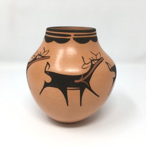 May include: A hand-painted pottery vase with a brown and black deer design. The vase has a rounded shape and a brown glaze.