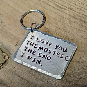 May include: Silver keychain with a hammered metal tag that reads "I love you the mostest. The end. I win."