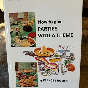 May include: A vintage book cover titled "How to Give Parties with a Theme" by Frances Rosien. The cover features illustrations of food and party decorations, including a sombrero, Eiffel Tower, and pineapple. The book is part of the Amy Vanderbilt Success Program for Women.