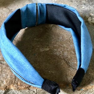 K&ouml;nnte beinhalten: Ein blaues Denim-Haarband mit Rei&szlig;verschlussdetail und schwarzem Gummiband auf der R&uuml;ckseite.