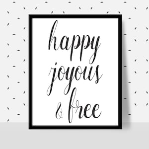 Peut inclure: Une affiche encadrée avec l'inscription "happy joyous & free" en écriture noire sur fond blanc. Le cadre est noir, et l'arrière-plan présente un motif de petites formes de feuilles grises.