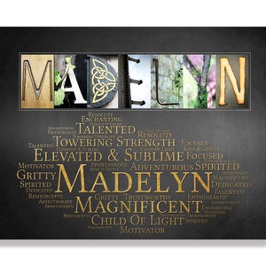 May include: A black and gold personalised name art print featuring the name "MADELYN" in large letters. The letters are made from various textures and patterns. The background is a dark grey with a subtle texture. The name is surrounded by a word cloud of positive adjectives in gold lettering.