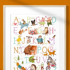 Peut inclure: Une affiche murale encadrée de l'alphabet présentant des lettres colorées de A à Z, chacune accompagnée d'une illustration aquarelle d'un animal ou d'un objet, comme un ours jouant du piano, un zèbre à vélo et un hérisson au xylophone.