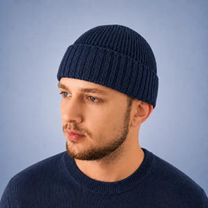 Peut inclure: Un bonnet bleu marine foncé fabriqué dans un tissu en maille côtelée épaisse. Le bonnet présente un large revers plié qui s'ajuste confortablement autour de la tête, mettant en valeur une texture verticale cohérente sur tout l'accessoire.