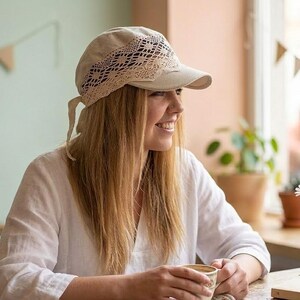 a woman enjoying the sun in a pastel linen headwrap, perfect for a romantic cottagecore look or a day at the seaside.