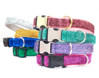 May include: A stack of six sparkly pet collars in various colors, including silver, gold, pink, teal, purple, and fuchsia. Each collar has a black buckle and a silver or gold D-ring.