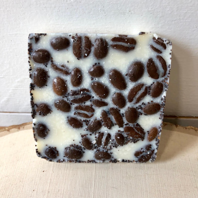 Puede incluir: Una barra de chocolate blanco con un patr&oacute;n de granos de caf&eacute; de chocolate negro.