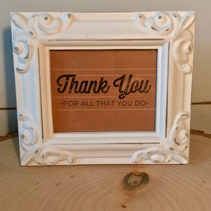 May include: White framed sign with a brown background and the text "Thank You - For All That You Do."
