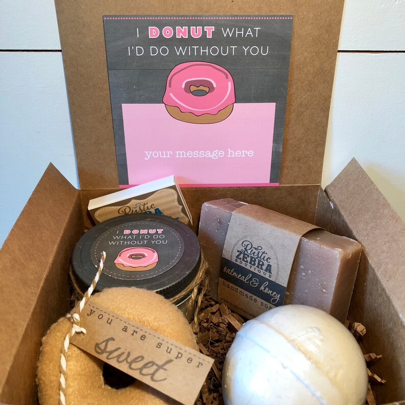 May include: A gift box filled with a donut-themed gift set. The box includes a donut-shaped bath bomb, a jar of bath salts, a bar of soap, and a donut-shaped plush toy. The box also includes a card with the text "I donut what I'd do without you" and a space for a personalized message.