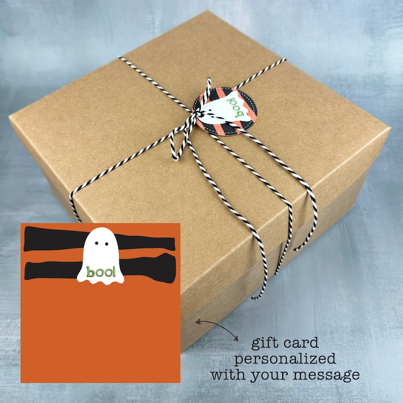 May include: A brown square gift box tied with black and white twine. A circular tag with the word "boo" and a ghost design is attached. A gift card with a ghost illustration is included.