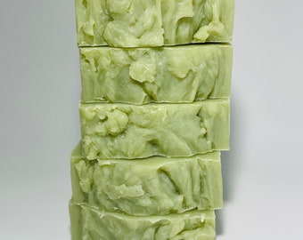 May include: A stack of five green soap bars with a swirl pattern. The bars are stacked on top of each other.