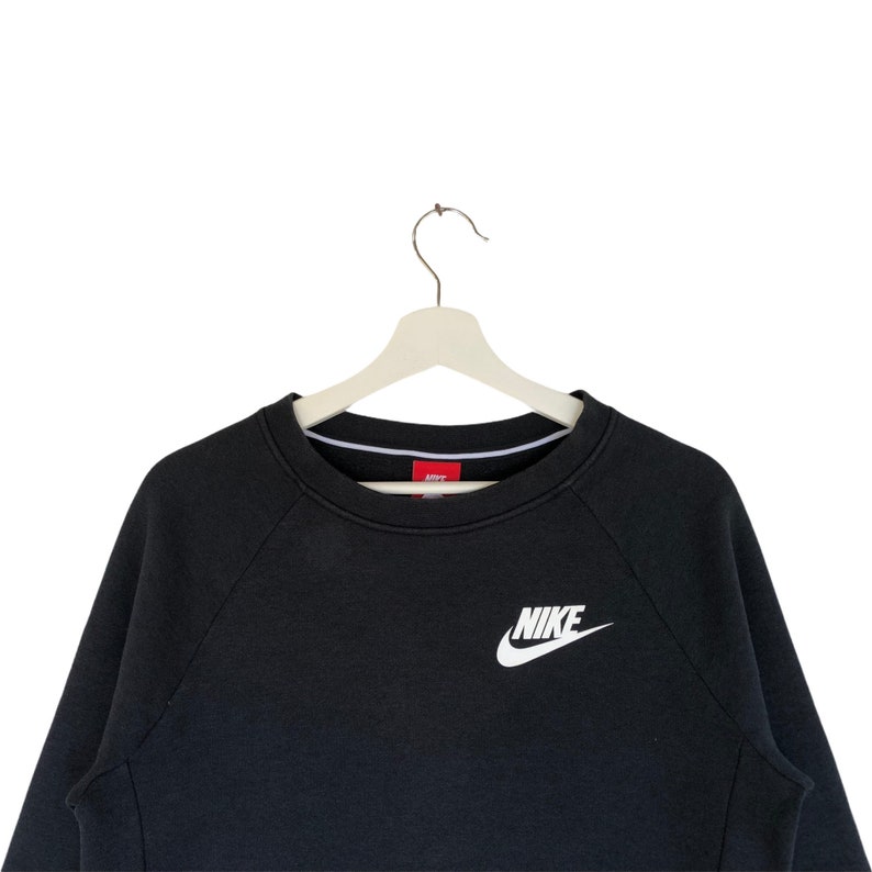 May include: Black sweatshirt with a white Nike logo on the front.