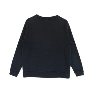 May include: A black long-sleeved sweatshirt with a crew neck and raglan sleeves.