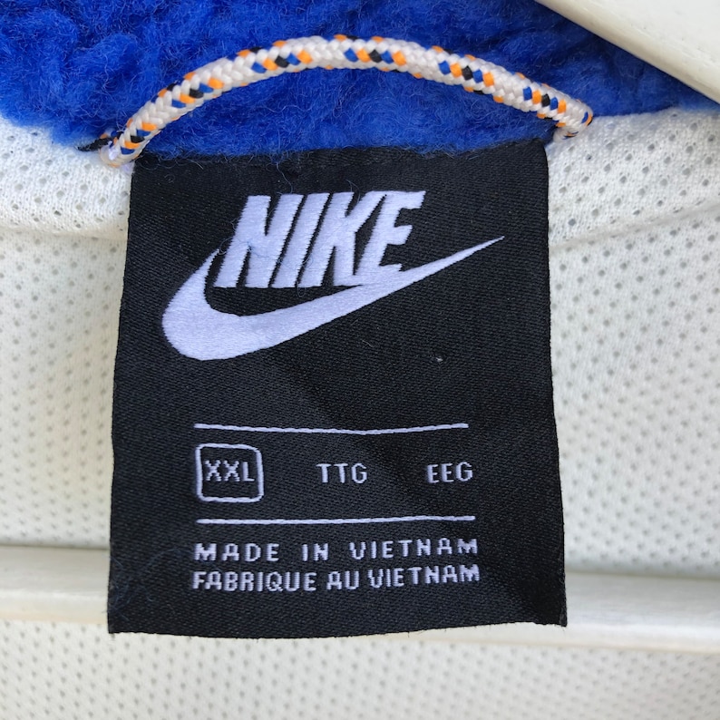 Puede incluir: Etiqueta Nike negra con logotipo blanco y texto blanco. La etiqueta dice "Nike" en blanco, en fuente estilizada y "XXL" en un cuadrado blanco. La etiqueta tambi&eacute;n dice "TTG" y "EEG" en blanco. La etiqueta dice "Hecho en Vietnam" y "Fabriqu&eacute; au Vietnam" en blanco.